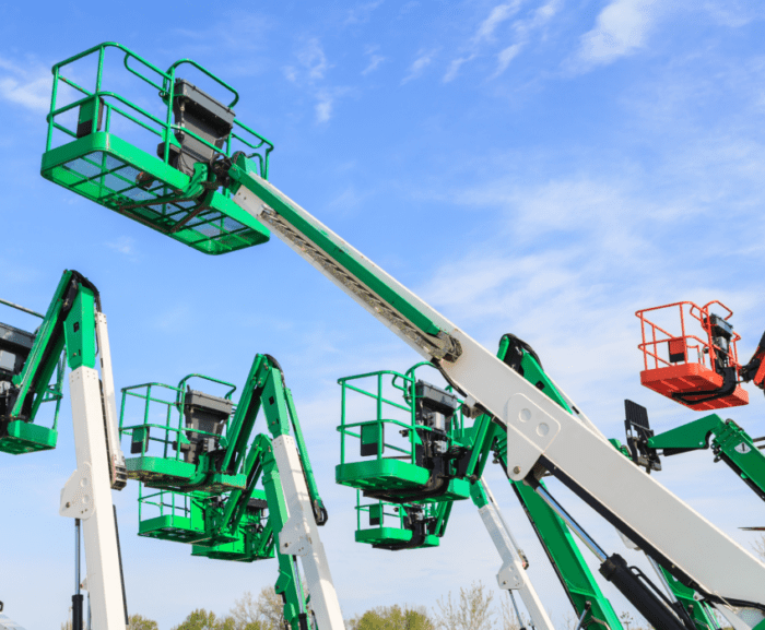 Boom lifts in green, white, and orange reach skyward in an organized lot, illustrating fleet management under a blue sky.