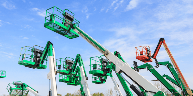 Boom lifts in green, white, and orange reach skyward in an organized lot, illustrating fleet management under a blue sky.