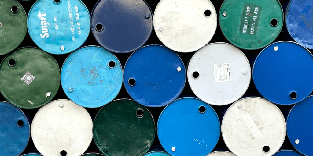 A stack of blue, green, and white barrels with visible labels and scratches, arranged horizontally—suggesting construction equipment tracking.