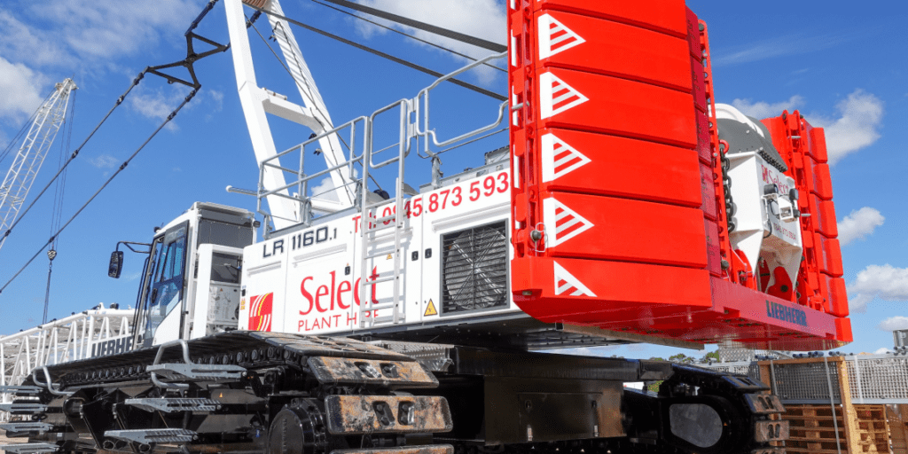 A large white and red Liebherr crawler crane is parked outside on a sunny day, showcasing construction equipment tracking.