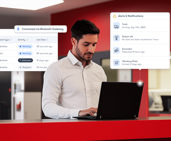 A man uses a laptop at a counter with digital graphics showing equipment status and alerts, illustrating construction IoT.
