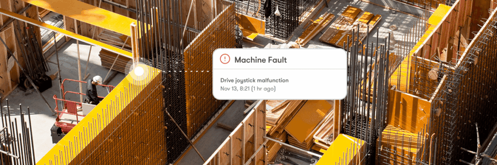 Aerial view of a construction site with two workers on a cherry picker and a machine fault alert—connected jobsite.