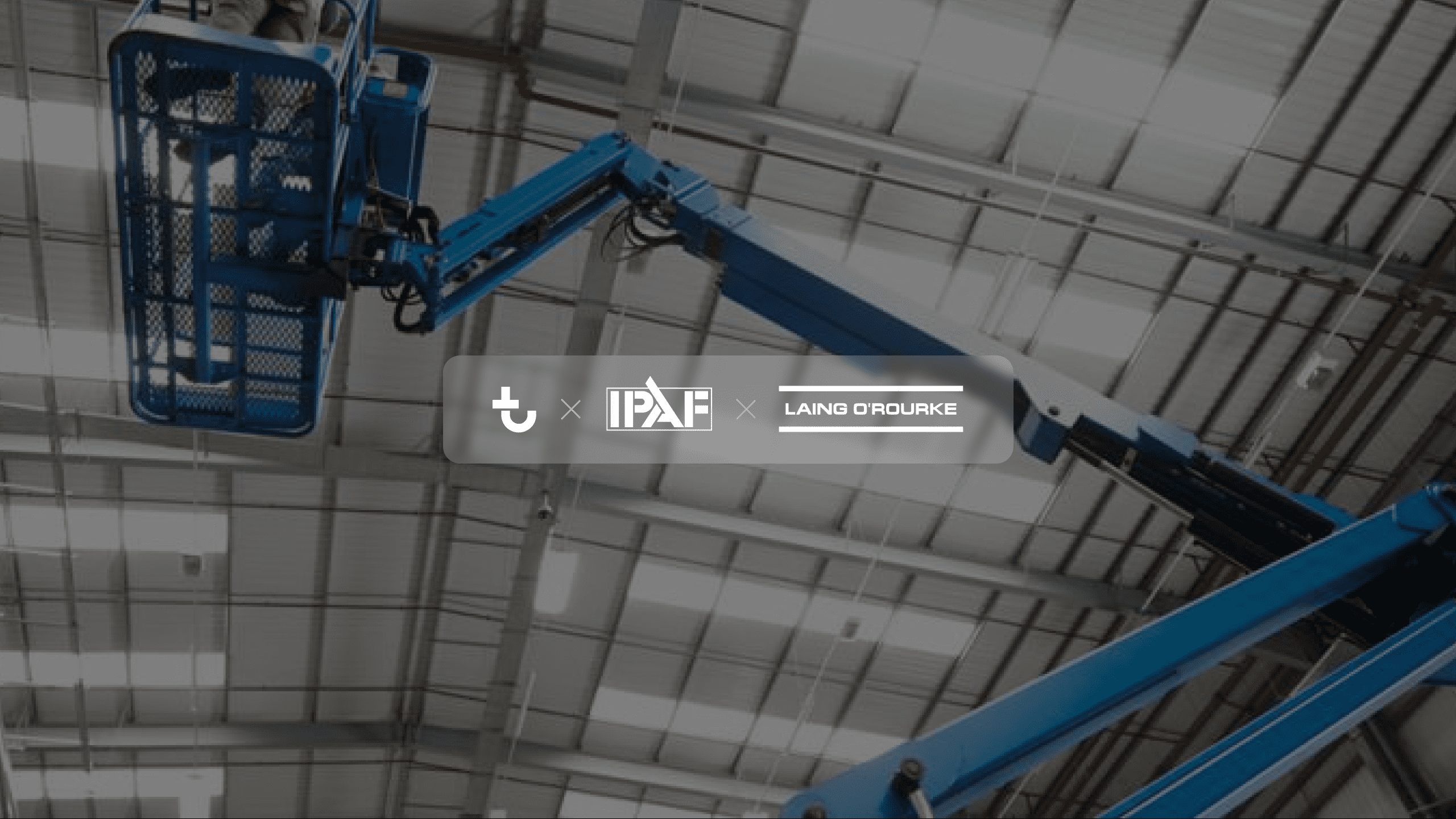 A blue boom lift extends toward the ceiling in a large industrial building; IPAF and Laing O'Rourke logos are centered on the image.