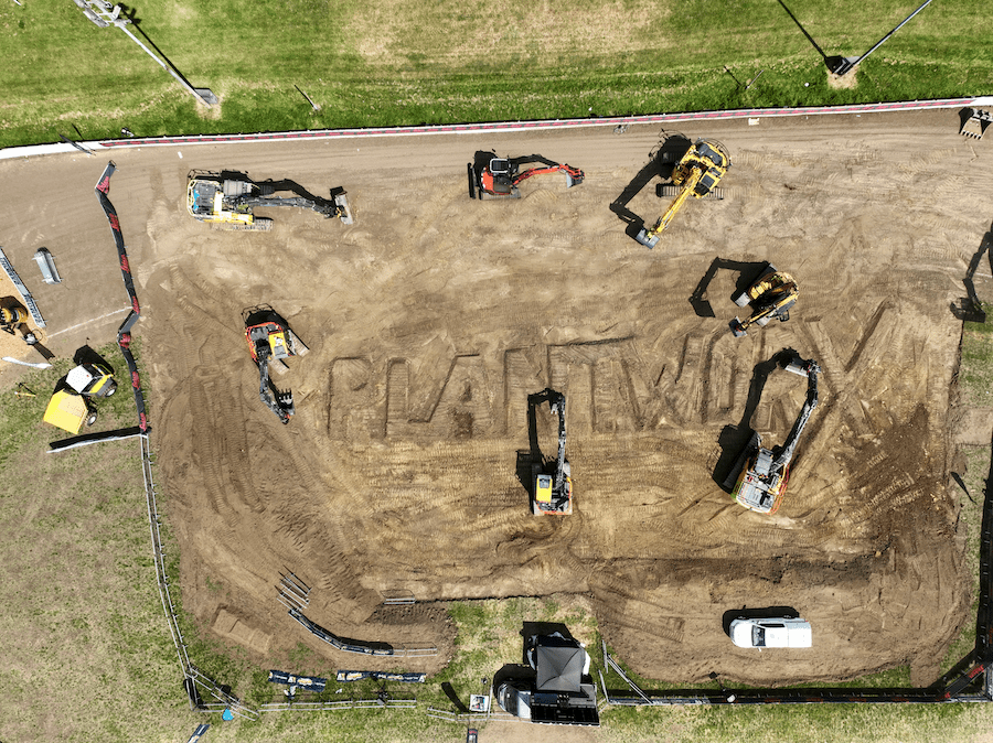 Aerial view of a construction site with excavators and a white truck, featuring PLANTWXY in the dirt, showing connected jobsite.