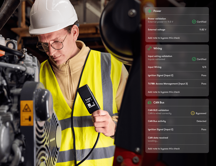 A man in a hard hat and yellow vest installs machinery with a diagnostic device; overlay shows power and wiring checks for connected jobsite.