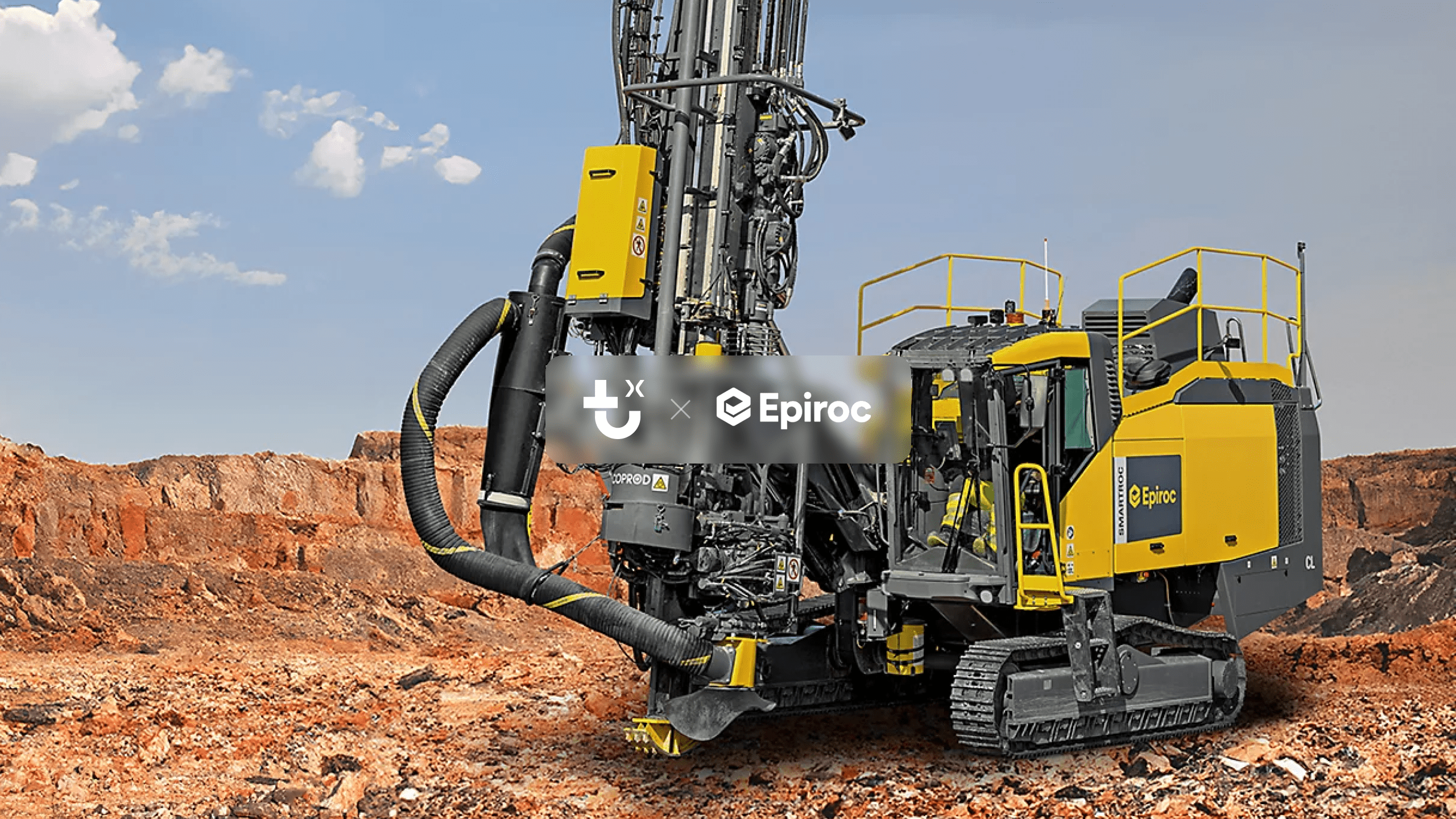 A large yellow and black Epiroc drilling machine operates on rocky terrain as workers manage tasks, with visible dust and equipment details; fleet management.