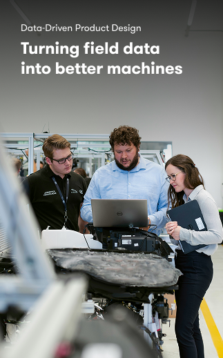 Three people discuss data for product design around a laptop in a modern industrial space, highlighting construction IoT benefits.