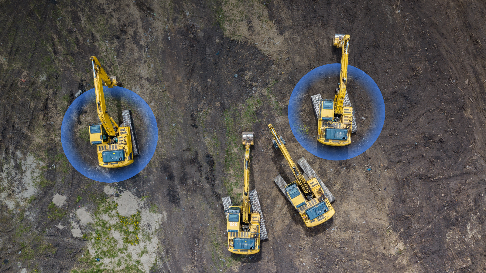 Aerial view of three yellow excavators on dirt with blue overlays showing operating ranges, illustrating construction equipment tracking.