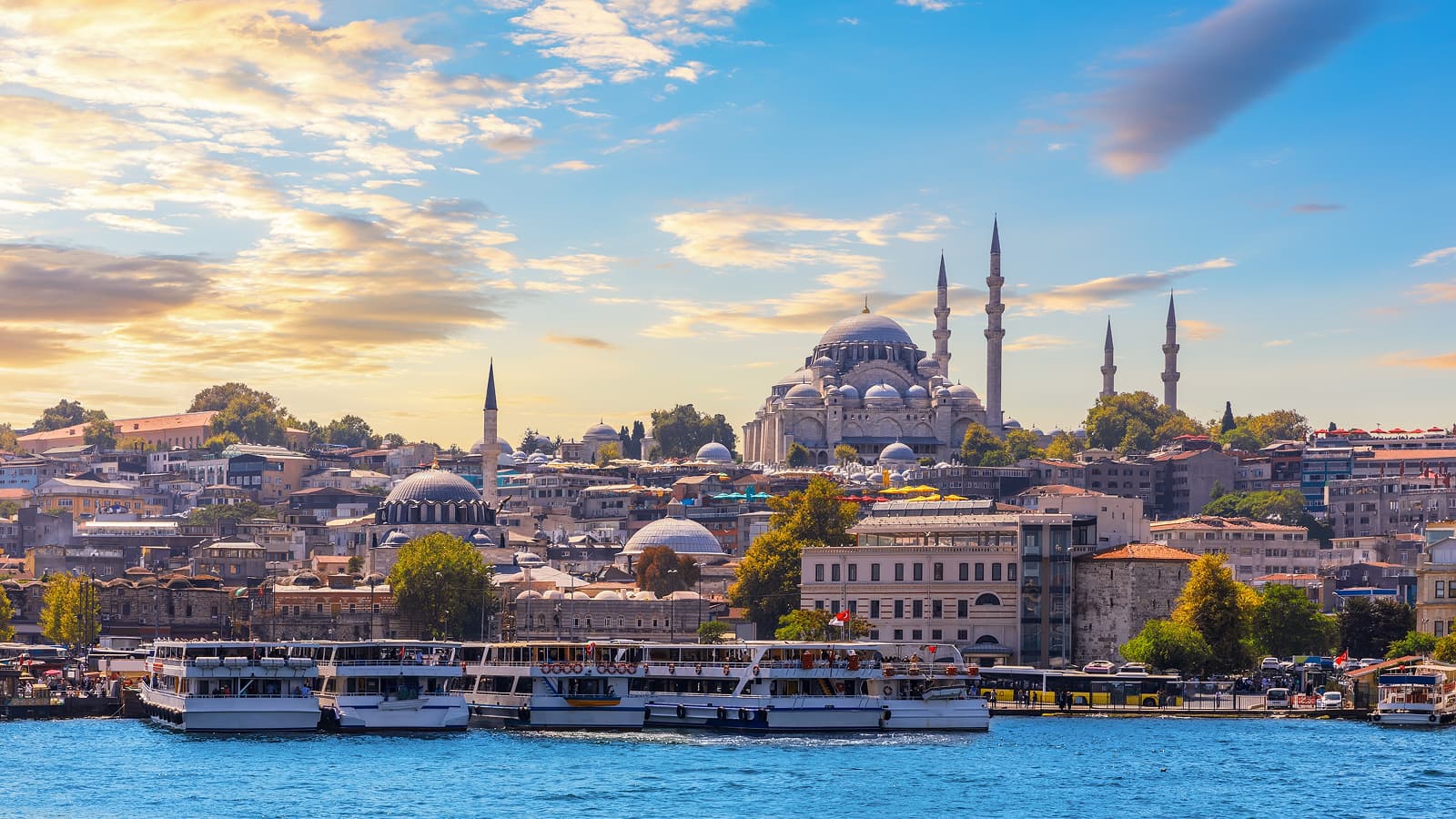 The Suleymaniye Mosque overlooks a crowded Istanbul waterfront where passenger boats are tracked as part of connected jobsite fleet management.
