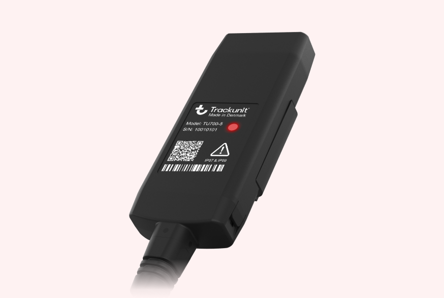 Trackunit TU700-5 telematics device with status indicator, QR code, and barcode label used for construction equipment tracking.