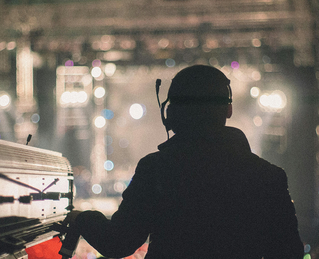 A person with a headset operates a stage light in a connected jobsite.