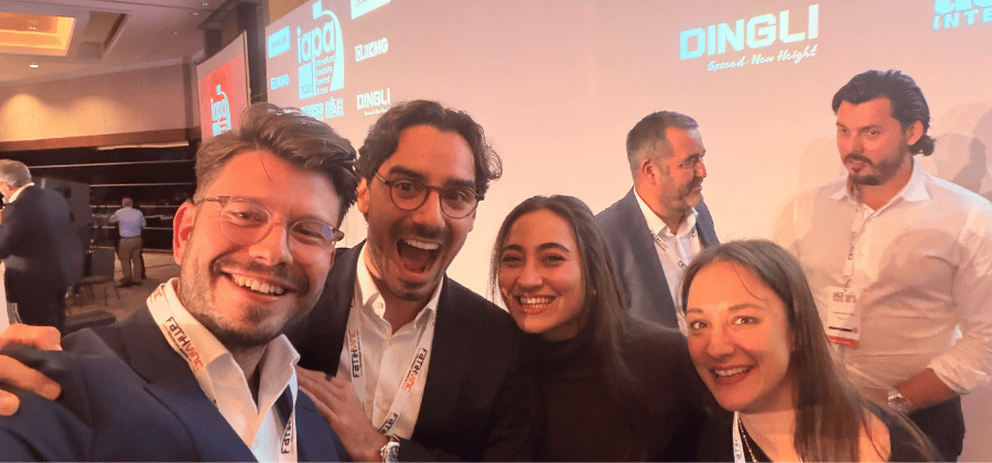 Four people posing for a group selfie at a connected jobsite corporate conference event.