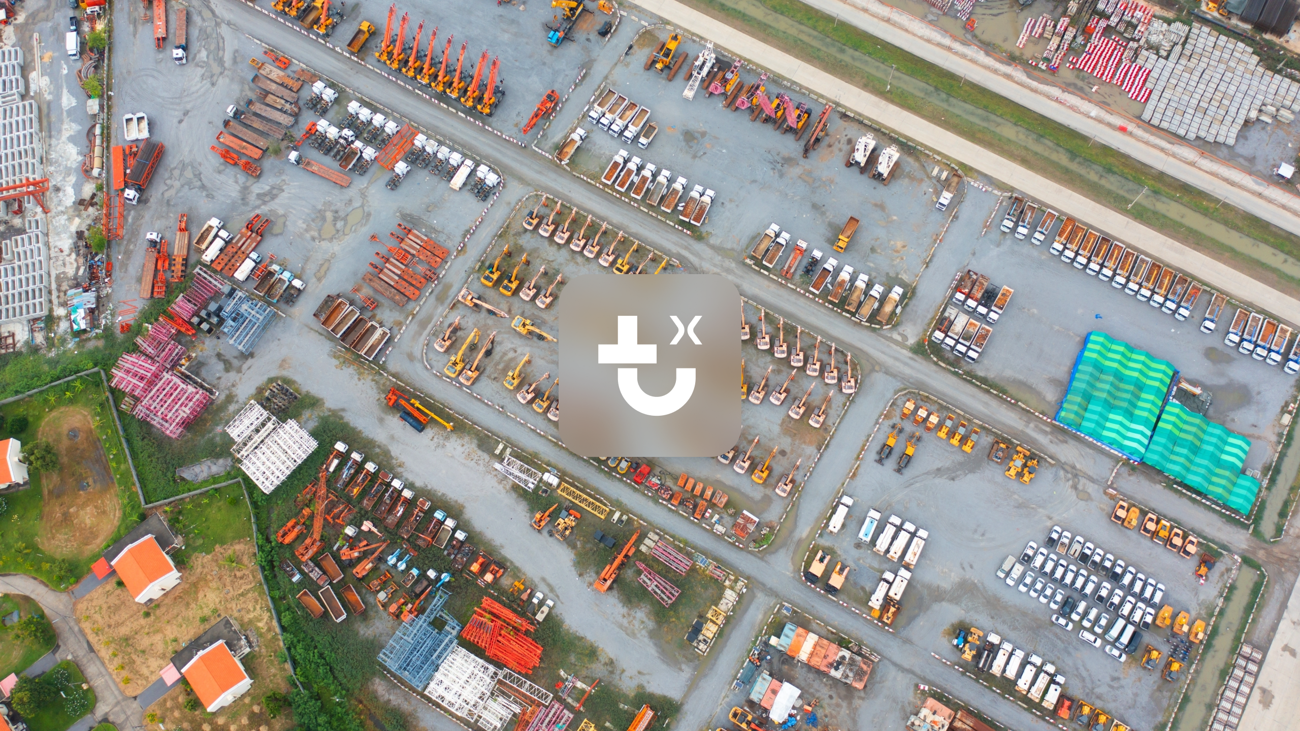 Aerial view of an IrisX yard with parked trucks, excavators, and construction materials for fleet management.