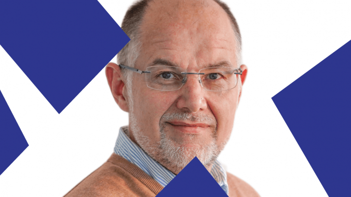 A middle-aged man with glasses and a short beard, in a brown sweater, is framed by blue geometric shapes, suggesting fleet management.