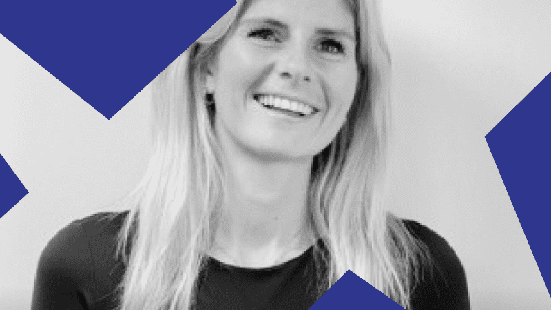 A woman with long blonde hair in a black top smiles at the camera. Black and white photo with blue shapes, hinting at connected jobsite.