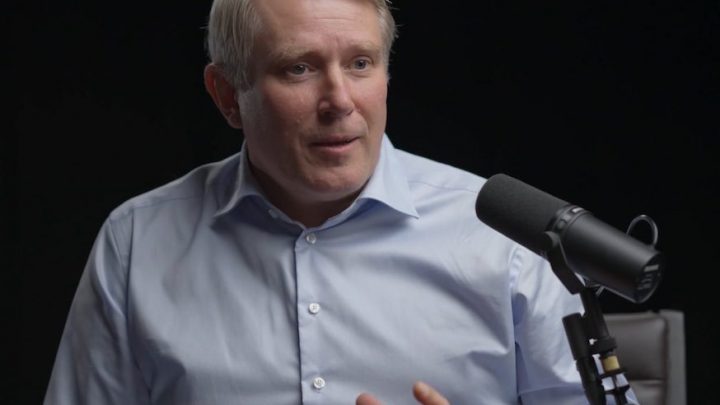 A man with light hair in a blue shirt speaks into a microphone about safe equipment access, relevant to fleet management.
