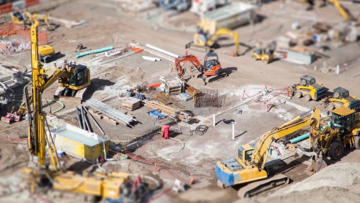 Aerial view of a busy construction site with excavators, machinery, and materials, highlighting construction equipment tracking.