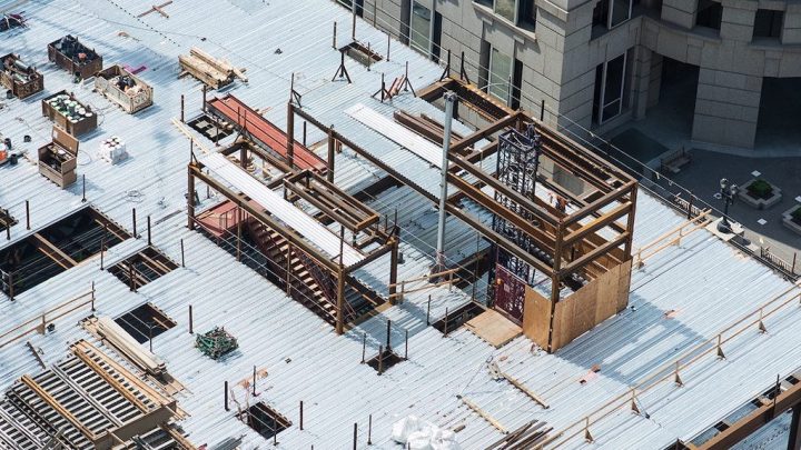 Aerial view of a construction site with steel beams, scaffolding, and materials, highlighting a connected jobsite.