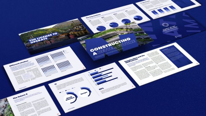 Open blue-themed booklets and construction reports with charts and infographics arranged on a blue surface.