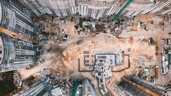 Aerial view of a large construction site with high-rise buildings, cranes, and materials, illustrating connected jobsite progress.