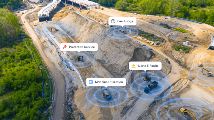 Aerial view of a construction site with icons showing machine data like utilization and faults above equipment for fleet management.