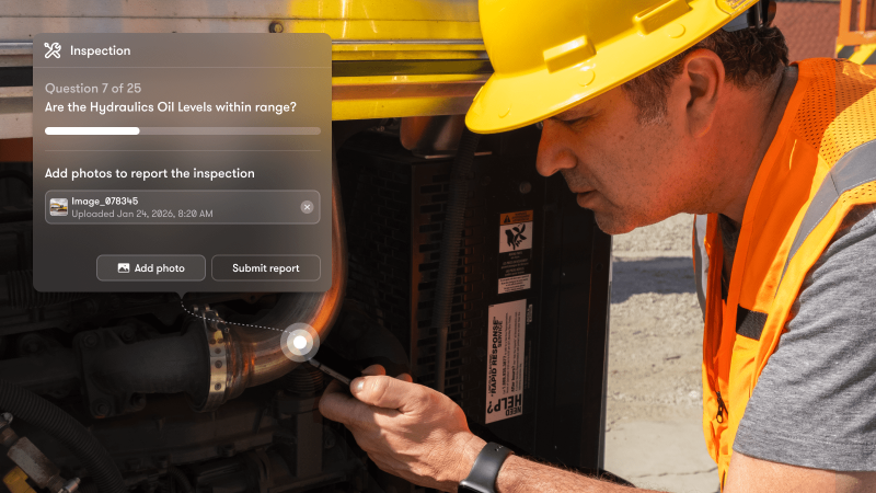 A man in a hard hat inspects outdoor machinery with a flashlight, next to a digital checklist for construction equipment tracking.