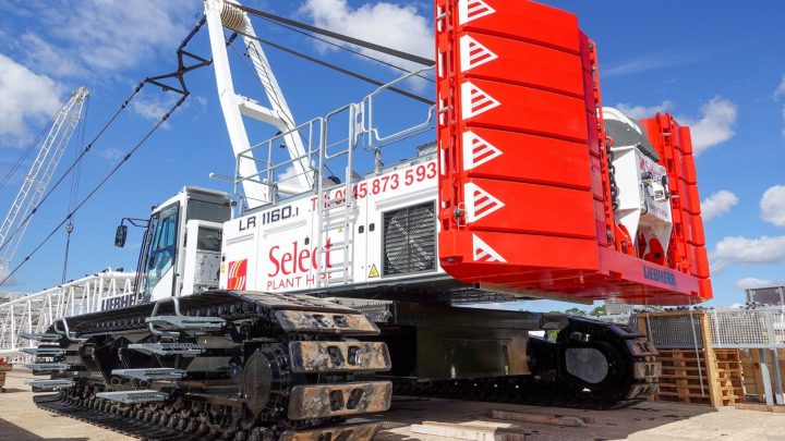 A white and red crawler crane with heavy-duty tracks and “Select Plant” branding is parked on a jobsite, showcasing fleet management.