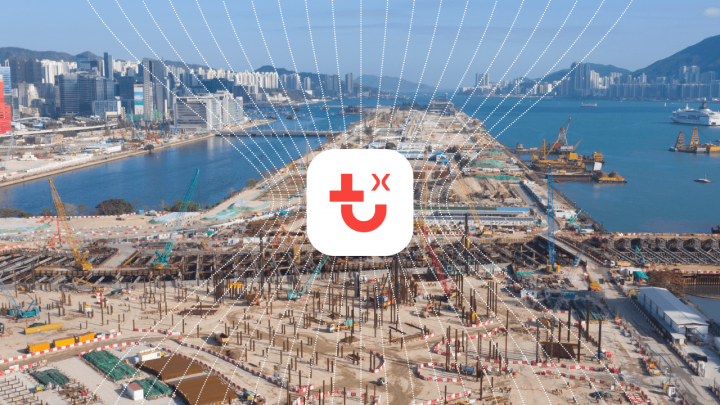 A large waterfront construction site with cranes and materials, set by a city skyline, highlights a connected jobsite.