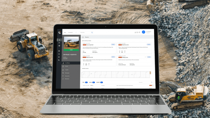 A laptop with a construction management dashboard is overlaid on a site where bulldozers work, highlighting connected jobsite.
