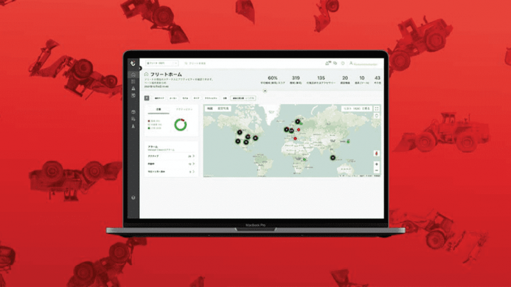 A laptop showing fleet management analytics on a world map, with a red background and subtle images of construction vehicles.