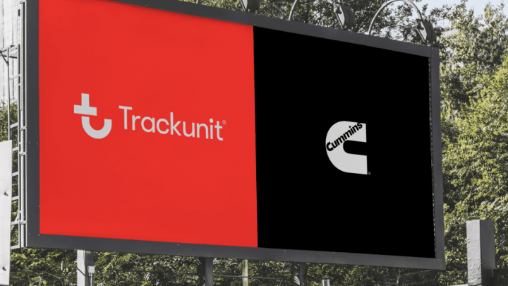 A billboard shows Trackunit and Cummins logos on red and black backgrounds, with trees behind. The bold Cummins logo stands out.
