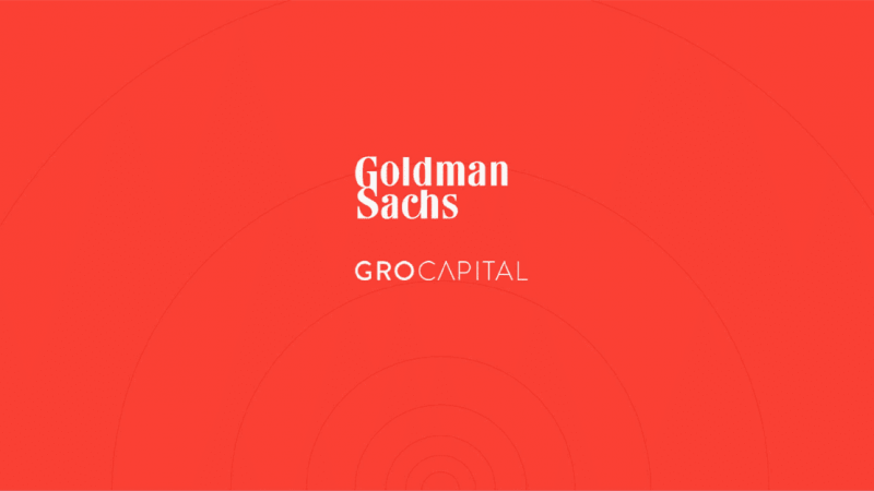 Goldman Sachs and GRO Capital logos centered on a red background with subtle circular patterns, referencing an acquisition.