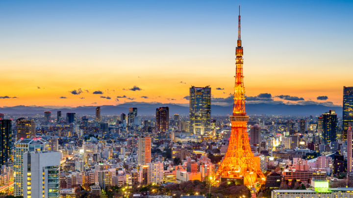 Tokyo cityscape at sunset with Tokyo Tower lit up, modern skyscrapers, and advanced telematics visible in the skyline.