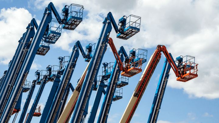Blue and orange boom lifts with extended arms stand outdoors under a partly cloudy sky, ready for digital inspection or fleet management.
